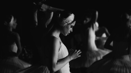 Ballerinas in white tutus, view from backstage. Black and white photos