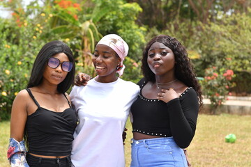 young beautiful african ladies taking a stroll in a garden having happy discussion