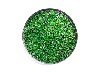 Clear green masterbatch granules in a cup, isolated on white background. Color pigment carrier...