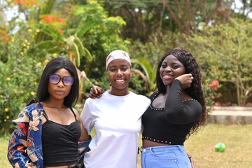 young beautiful african ladies taking a stroll in a garden having happy discussion