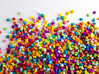 Various colors of masterbatch granules mixed on a white background.Color pigment carrier polymers in the plastics industry