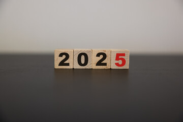 Wooden cube block with 2025 text on table background. Resolution, plan, review, goal, start and New Year holiday concepts