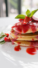 breakfast pancakes with strawberry jam on white background, vertical photo