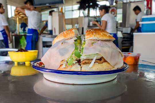 Traditional Cemita poblana with Milanese, quesillo, avocado and papalo at a local market in Puebla, Mexico"