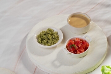 Red, yellow and green sauce in bowls on light background