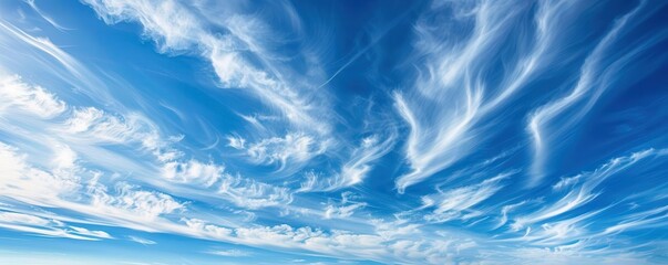 Obraz premium Wispy clouds forming delicate patterns in a vivid blue sky, delicate clouds, elegance