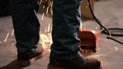 Welders shoes with sparks landing by feet 1