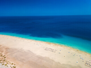 Obraz premium White sandy beach and blue water in Morro Jable, south of Fuerteventura, Canary islands
