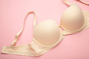 Beige female bra on beige background. Compression bra for breast. Top view