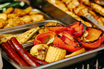 Assorted grilled vegetables and meat and sausages, showcasing a colorful breakfast.