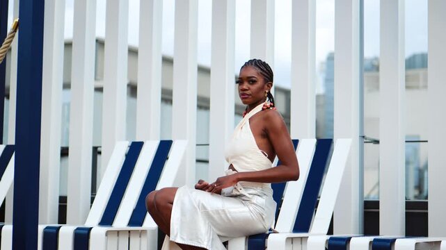 Black woman sitting in a lounge chair, in a tight skirt