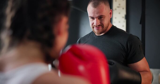 Sports, fitness or boxing with woman and coach at gym for training, practice or spar in preparation for fight. Exercise, health or workout with boxer and personal trainer together for self defense