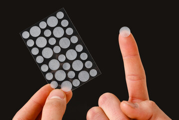 Skin care with acne pimple patches on black background. Easy way to get rid of problematic zits on...