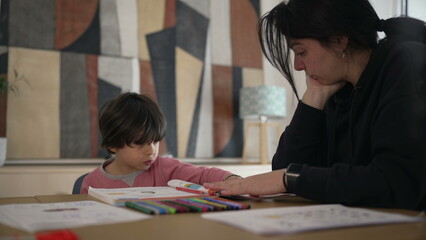 Child and adult interacting over a colorful workbook, engaged in a learning activity at home, highlighting the importance of education and bonding through shared activities and creativity