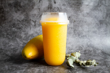 Mango Frappe shake juice served in disposable glass isolated on grey background side view healthy fresh juice