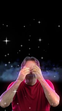 Vertical view of a man giving two mind blown meme gestures. Space background.  	