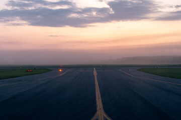 Looking down the airport runway at sunrise