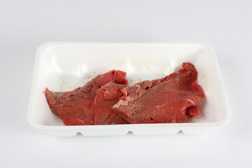 raw steak in a plastic container isolated