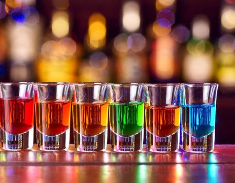 A line of colorful shots on a bar background.