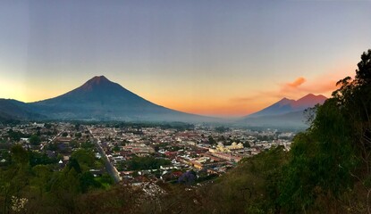 Sunrise over city and volcanos  © Anna