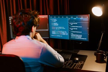 Working IT developer concentrating online software development information on surrounded by coding...