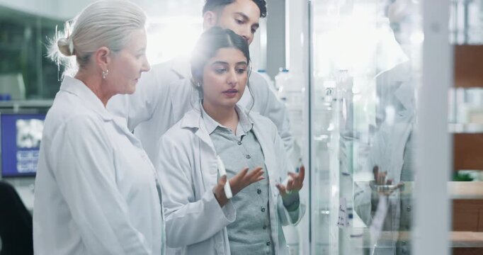 Science, team and writing with glass in laboratory for tracking experiment progress, brainstorming and research. Scientist, collaboration and equation or formula for prediction, analysis and theory.