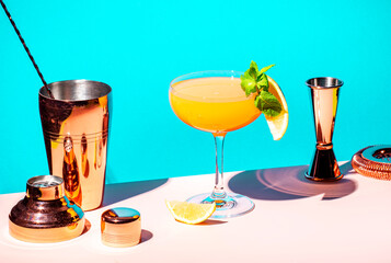 Yellow alcoholic cocktail drink with rum, liquor, grapefruit and lemon juice. Blue background, hard light and shadows