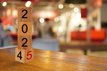 Wooden cube blocks with 2025 text on table top with blur background. Resolution, plan, goal, start and New Year holiday concepts.