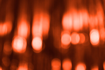 Blurred red abstract background with light bokeh. Festive, Christmas, New Year, Valentine's or anniversary party. Decoration and holiday illumination concept