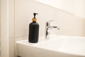 A bottle with liquid soap on the water basin
