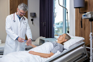 Obraz premium Doctor making a list of prescriptions to a patient in an intensive therapy department