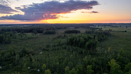 Vibrant Sunset Over Lush Green Landscape in Rural Area During Early Evening Hours