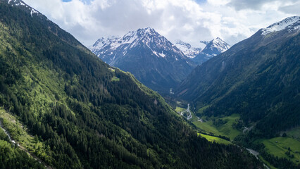 Obraz premium Breathtaking Aerial Landscape View of Snow-Capped Mountains and Lush Valleys During Daylight in the Alps