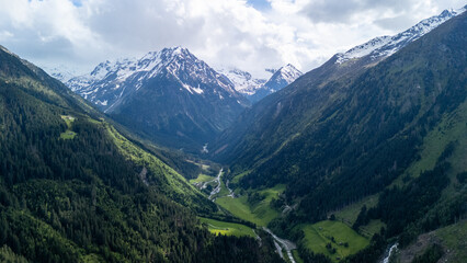 Stunning Aerial View of Snow-Capped Mountains and Lush Valleys in Summer