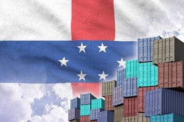 Netherlands Antilles flag and big stack of shipping cargo containers in docks with sky background close up