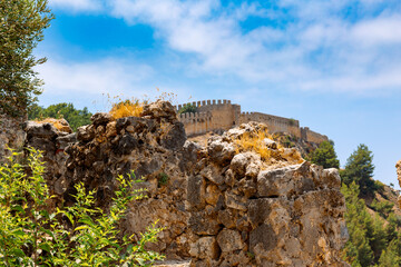Fototapeta premium Landscape view old walls of fortress on Mediterranean coast. View of Alanya Castle, stone ruins in Alanya, Turkey