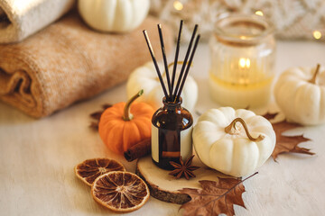 Cozy corner for home meditation and relaxation. Aroma diffuser, burning candles, pleasure and aromatherapy. Fall decor with pumpkins for apartment, house, indoors design. Thanksgiving decoration