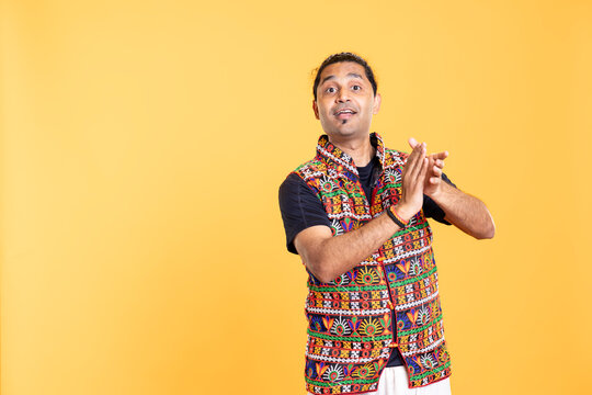 Joyful man happily clapping hands, ecstatic about accomplishments, celebrating. Excited person reacting to good news, cheering, applauding, isolated over studio background