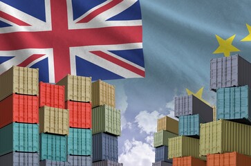 Tuvalu flag and big stack of shipping cargo containers in docks with sky background close up