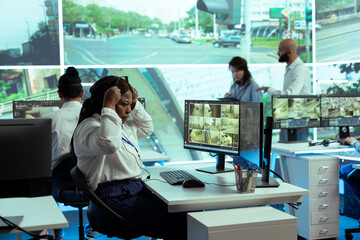 African american dispatch employee uses public satellite sensors to ensure safety in city streets,...