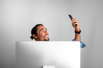 Latino man takes a selfie while working.