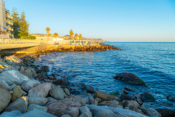 A seaside outdoor cafe patio along the rocky coastline of the Italian resort town of Sanremo, Italy...