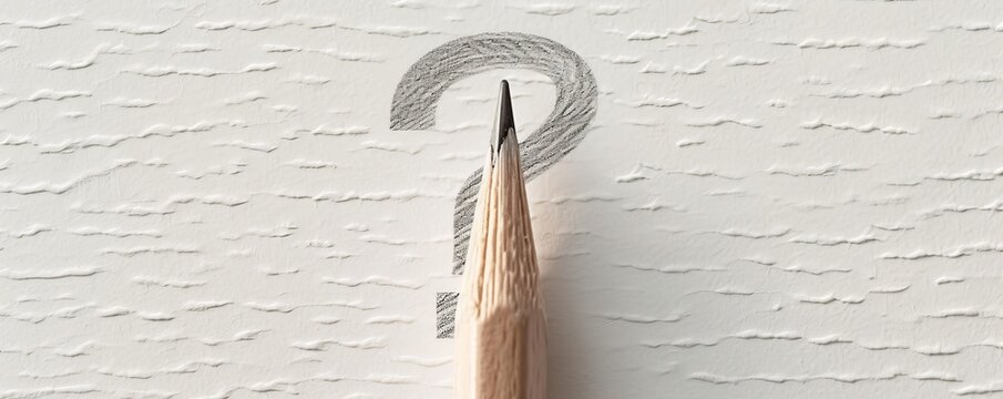 Pencil tip on textured white paper with question mark