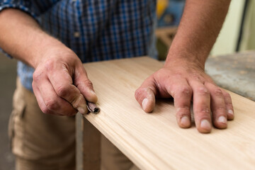 The carpenter grinds the edge with sandpaper