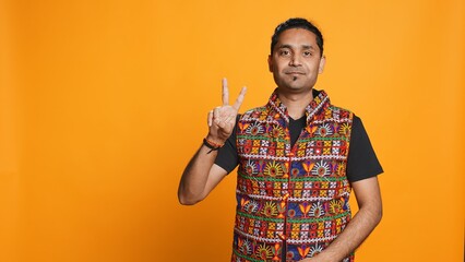 Portrait of upbeat man crossing fingers to make wish, hoping for good luck, isolated over studio...