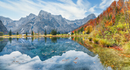 Breathtaking autumn scene of sunny morning on Almsee lake.
