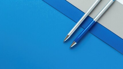 Stationery arrangement in blue and silver colors from a top diagonal view with space for text