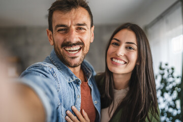 Self portrait of happy couple hug and have fun at home