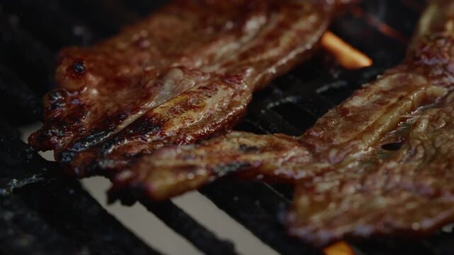 During the sunset, Kalbi meat sizzled on the gas grill in the front yard, the marinated beef caramelizing to perfection, its aroma mingling with the evening breeze, creating a mouthwatering scene.