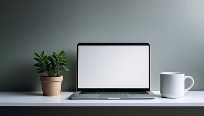 Minimalist workspace with a laptop, a coffee mug, and a potted plant on a white desk against a neutral background.